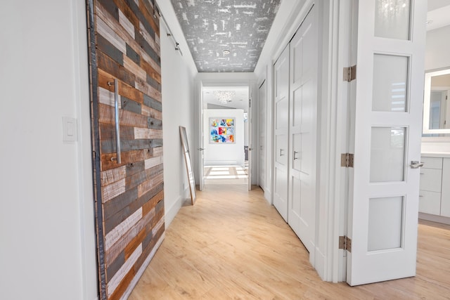 hallway featuring crown molding and light hardwood / wood-style flooring