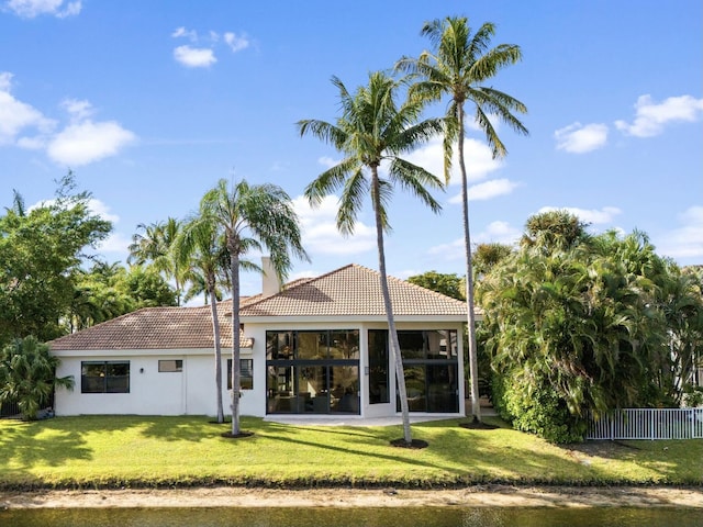 rear view of property featuring a lawn