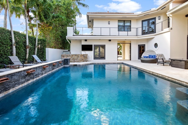 view of pool featuring a bar and a patio