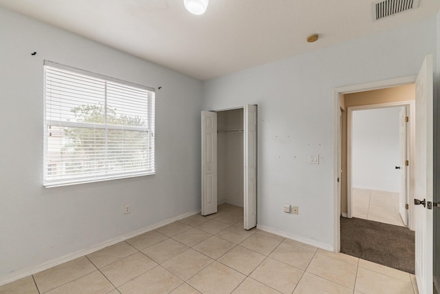 unfurnished bedroom with light tile patterned flooring and a closet