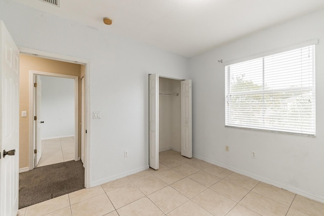 unfurnished bedroom featuring a closet and light tile patterned floors