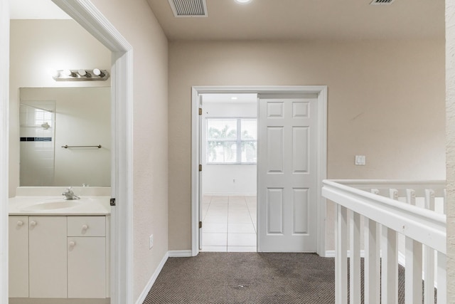 corridor featuring carpet floors and sink