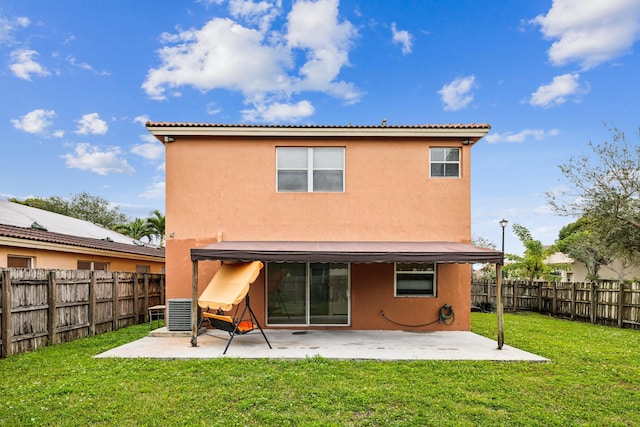 back of house featuring a lawn and a patio