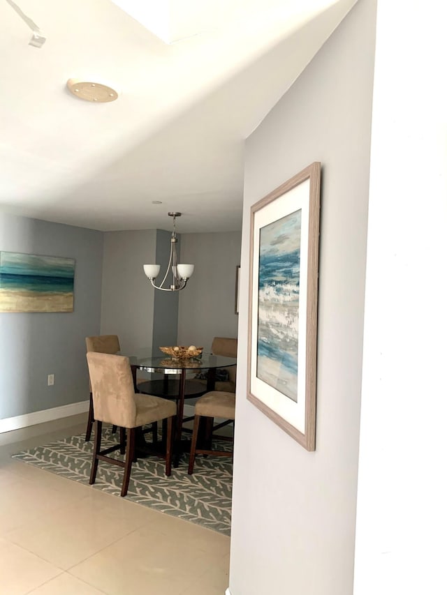 dining area featuring tile patterned floors and a chandelier