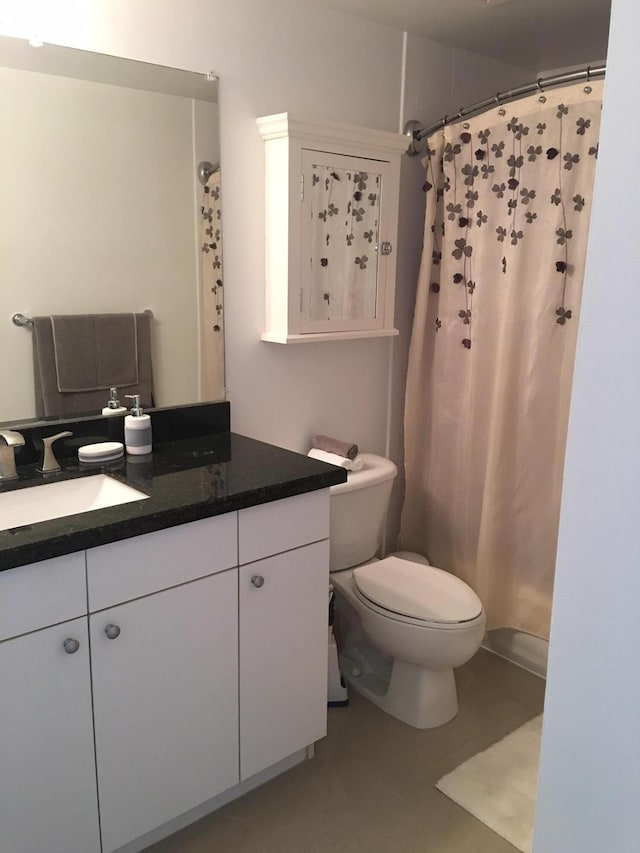 bathroom with toilet, curtained shower, and vanity