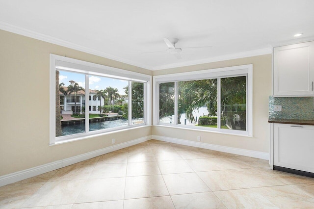 unfurnished dining area with a water view, light tile patterned floors, ceiling fan, and crown molding