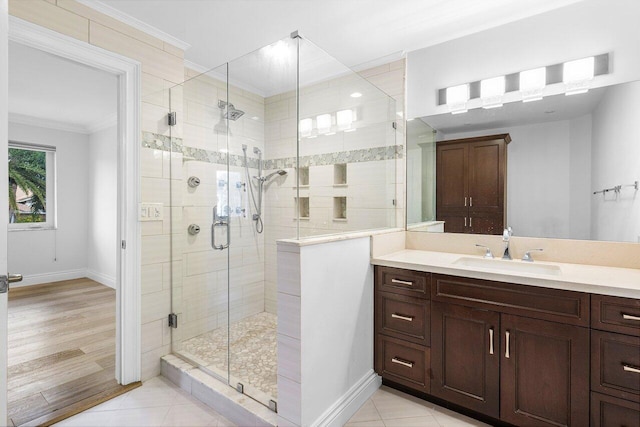 bathroom with vanity, tile patterned floors, a shower with door, and ornamental molding