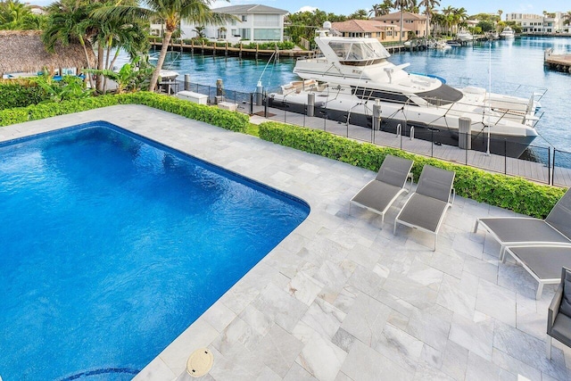 view of swimming pool featuring a water view and a patio area