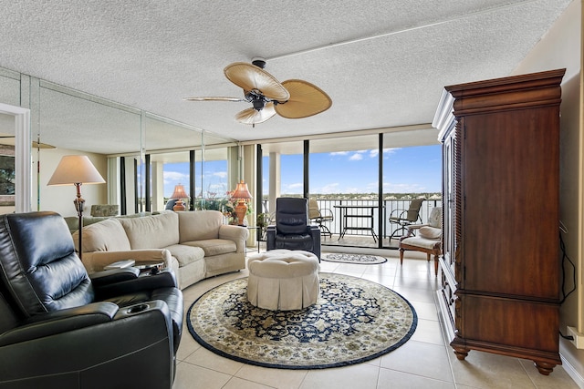 living room with ceiling fan, light tile patterned floors, and expansive windows