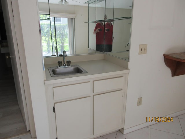 kitchen with white cabinets, light tile patterned flooring, and sink