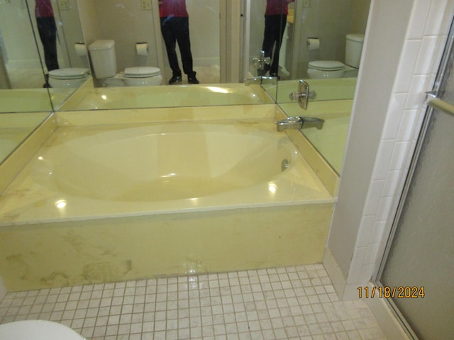 bathroom featuring walk in shower, tile patterned floors, and toilet