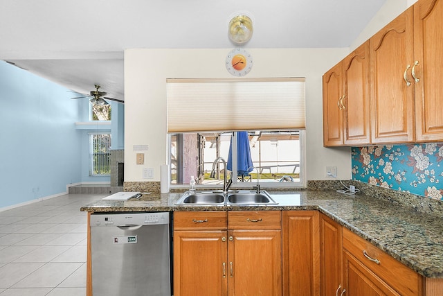 kitchen with sink, dishwasher, ceiling fan, light tile patterned floors, and dark stone counters