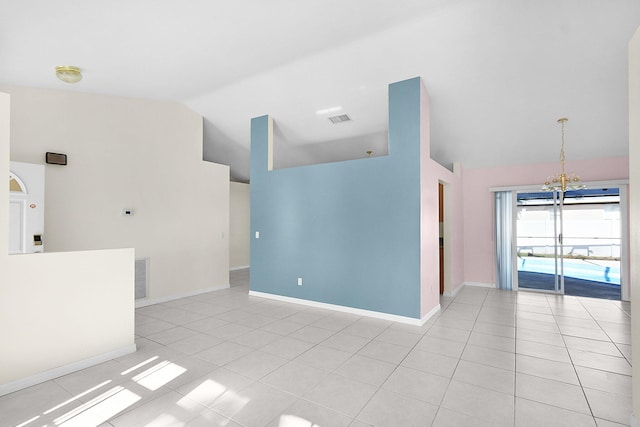 tiled empty room with vaulted ceiling and a chandelier