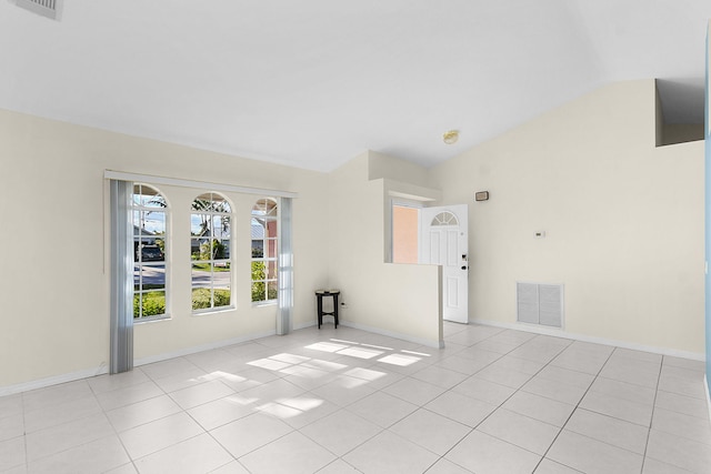 unfurnished room with lofted ceiling and light tile patterned floors