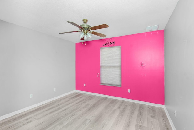 empty room with a textured ceiling, ceiling fan, and light hardwood / wood-style flooring