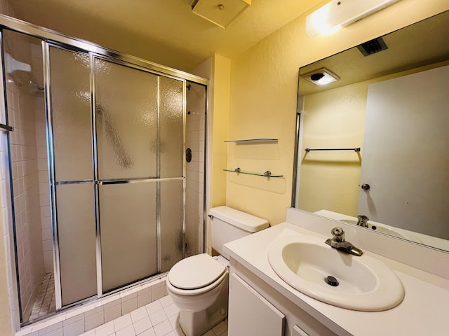 bathroom featuring a shower with shower door, toilet, vanity, and tile patterned flooring