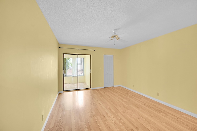 unfurnished room with a textured ceiling, baseboards, a ceiling fan, and light wood-style flooring