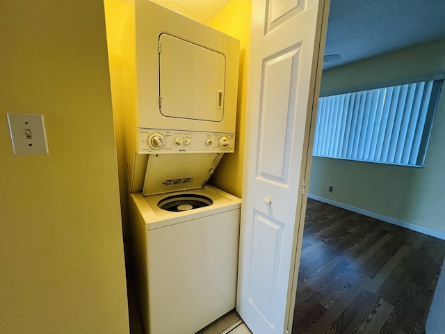 laundry room featuring stacked washer / dryer and hardwood / wood-style floors