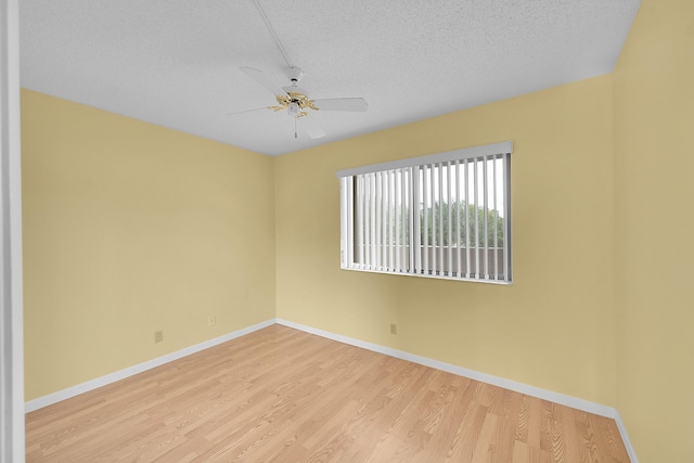 empty room featuring baseboards, a textured ceiling, ceiling fan, and wood finished floors