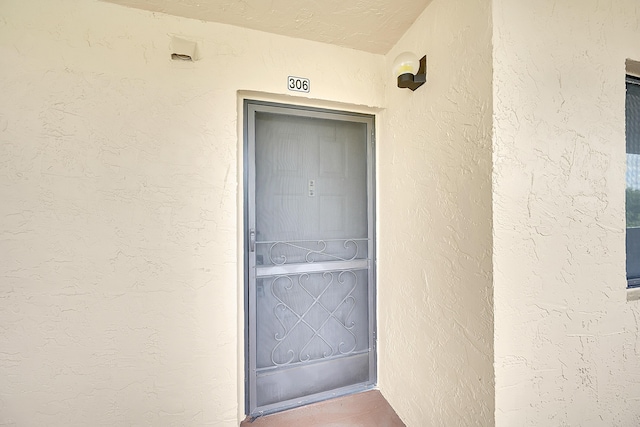 property entrance with stucco siding