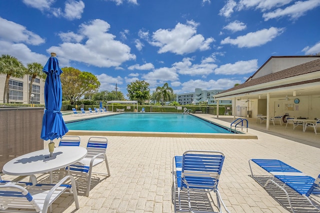 community pool with fence and a patio area
