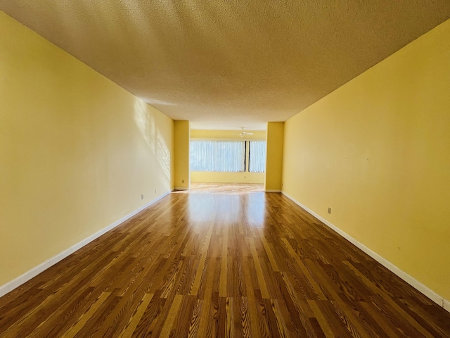 unfurnished room featuring a textured ceiling, ceiling fan, and dark hardwood / wood-style flooring