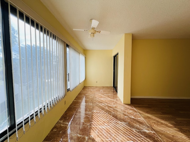 interior space with ceiling fan and a textured ceiling