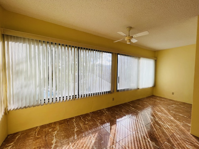 unfurnished sunroom with ceiling fan