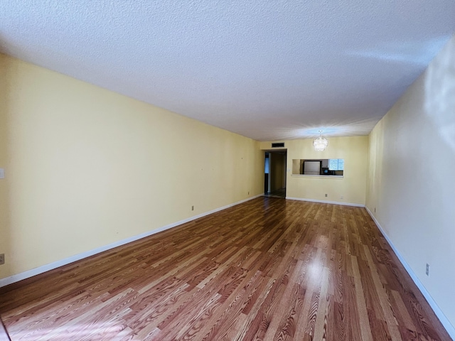 unfurnished living room featuring wood-type flooring and a textured ceiling