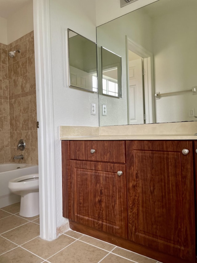 full bathroom with toilet, tile patterned floors, vanity, and tiled shower / bath