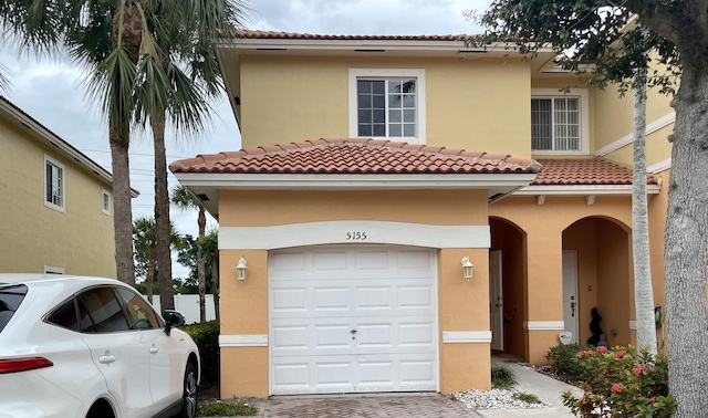 mediterranean / spanish home featuring a garage