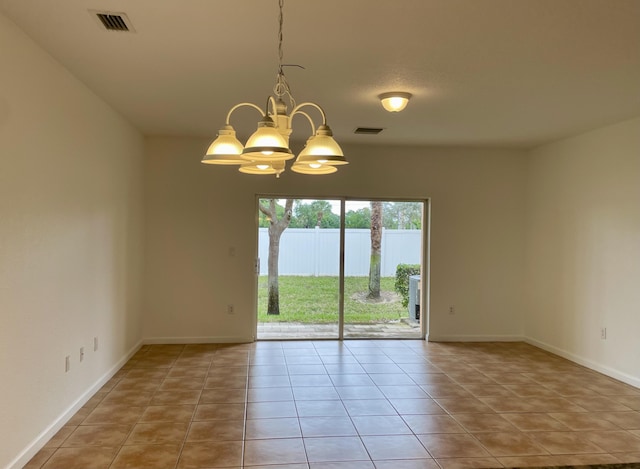 tiled spare room featuring a notable chandelier