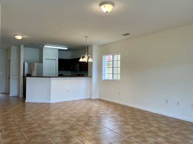 kitchen featuring light tile patterned floors, kitchen peninsula, stainless steel fridge with ice dispenser, and a chandelier