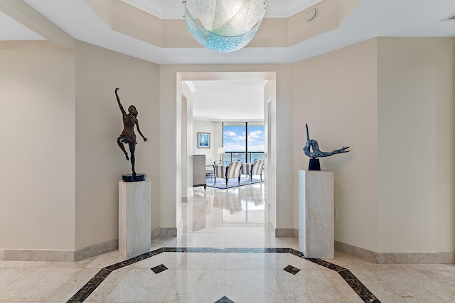 corridor featuring crown molding and a raised ceiling