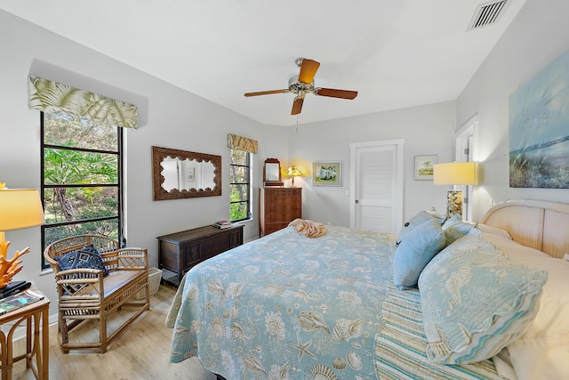 bedroom with ceiling fan, light hardwood / wood-style floors, and a closet