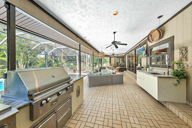 view of patio / terrace featuring sink, a lanai, an outdoor living space, area for grilling, and an outdoor kitchen