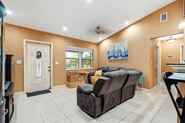 tiled living room featuring ceiling fan and vaulted ceiling