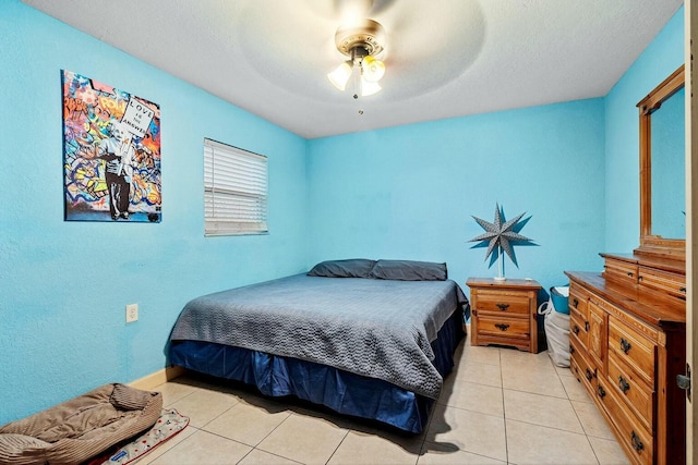 tiled bedroom with ceiling fan and a textured ceiling