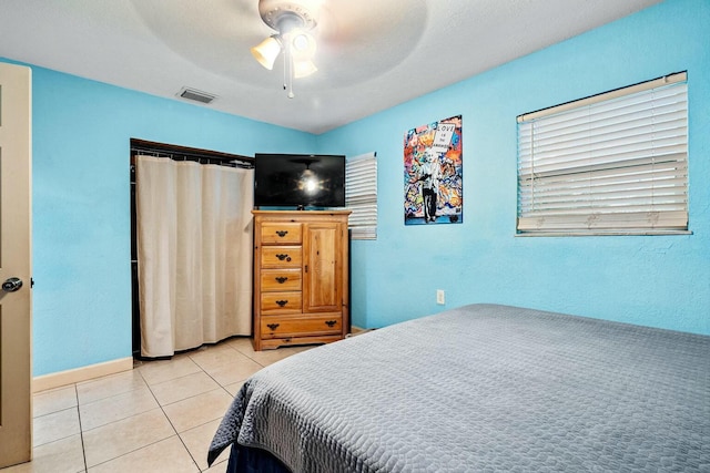 tiled bedroom featuring ceiling fan