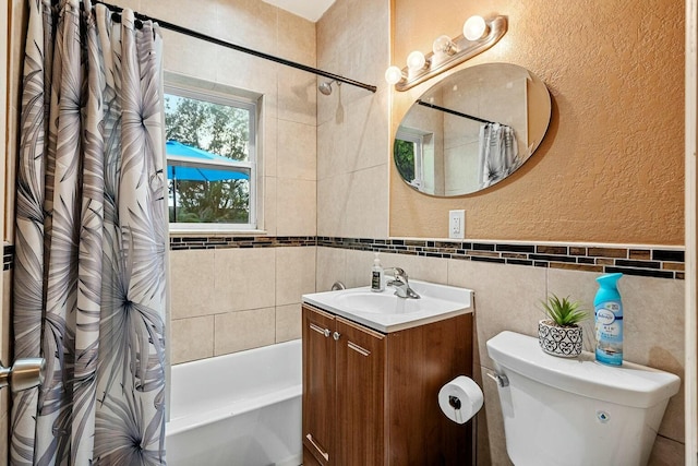 full bathroom with toilet, vanity, tile walls, and shower / bath combination with curtain