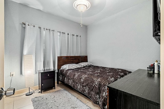 bedroom with ceiling fan and light tile patterned floors