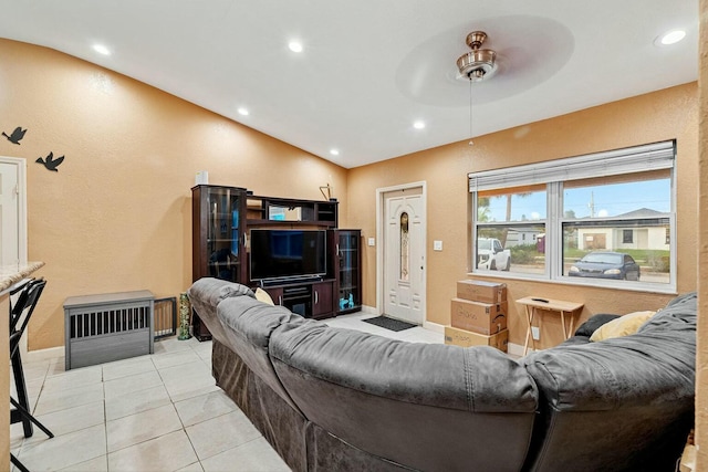 tiled living room with ceiling fan and vaulted ceiling