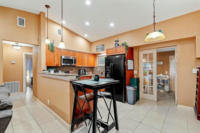 kitchen with a kitchen bar, kitchen peninsula, backsplash, hanging light fixtures, and appliances with stainless steel finishes