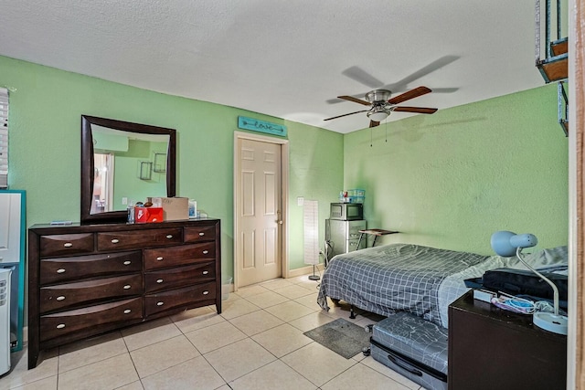 bedroom featuring a textured ceiling, light tile patterned flooring, and ceiling fan