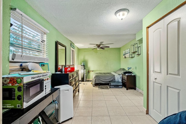 tiled bedroom with a textured ceiling, fridge, ceiling fan, and a closet