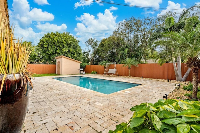 view of pool featuring a patio and a storage shed