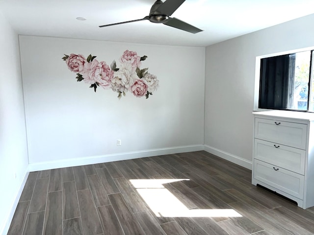 spare room featuring ceiling fan and dark hardwood / wood-style flooring