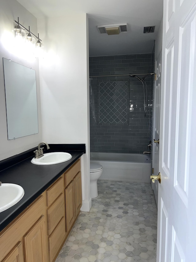 full bathroom with toilet, vanity, and tiled shower / bath