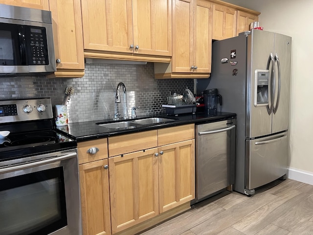 kitchen featuring decorative backsplash, sink, light hardwood / wood-style flooring, appliances with stainless steel finishes, and light brown cabinetry