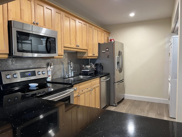 kitchen featuring backsplash, appliances with stainless steel finishes, sink, and light brown cabinetry